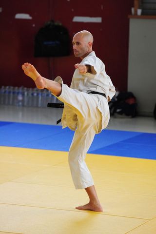 יניב מורסיאנו מבצע בעיטה על הטאטאמי, בגי לבן ובחגורה שחורה